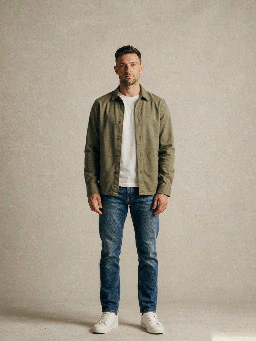 Full body, front view: olive overshirt worn open over a plain white crewneck tee, straight-leg mid-indigo jeans and clean minimal white sneakers
